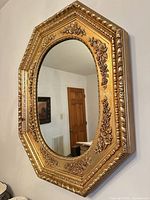 Front view showing entire octagonal gilded mirror on wall
