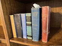 All six books upright on shelf showing spines
