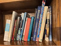 Shelf of assorted hardcover history, reference and décor books