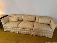 Full front view of sofa showing cushions and skirt