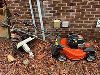Left side view of complete mower showing deck, engine, handle