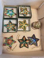 Top view showing six star ornaments in small boxes and heart ornament