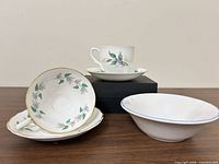 Group shot of all items: teacup and saucer set, separate floral cup, bowl