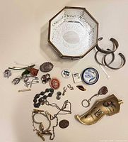 Entire lot laid out showing trinket box, ashtray, cuff bracelets, assorted jewellery