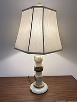 Lit onyx stone table lamp with octagonal shade on wooden surface