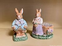 Front view of both ceramic rabbit figurines with attached baskets