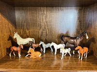 Shelf view showing all eight porcelain horses