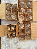Three divided cardboard boxes containing clear stem glasses viewed from above