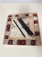 Boxed game with marbles, rods and instruction sheet