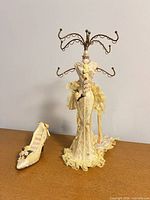 Full view of mannequin jewelry stand and shoe ring holder on tabletop