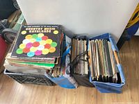 Three containers holding stacks of 12" vinyl LPs, top record Country Music Cavalcade visible