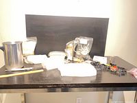 Overall view of wax blocks, pouring pot, tins, cookie cutters, wicks on table