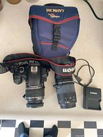 Full lot showing camera with 18-55 mm lens attached, 75-300 mm lens, Canon charger, Lowepro bag