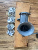 grinder beside six packaged plates on wood board