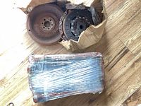Flywheel, clutch disc, and wrapped oil pan on floor
