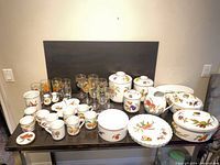 Full lot overview showing porcelain dinnerware, glass stemware, canisters, casserole, pitcher and pie dish