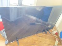Front view of 50-inch Insignia TV on floor stand feet