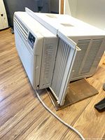 Left/front view of LG LW1212ER window air conditioner with side accordion panel and power cord visible