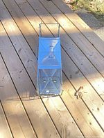 Oblique view of full trap showing handle, solid top, and wire cage body