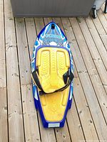 Top view of blue O'Brien Voodoo kneeboard showing yellow pad and strap