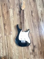 Full front view of Peavey black electric guitar on floor
