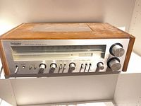 Front view showing silver face, control knobs, tuning dial, wood cabinet