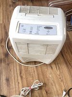 Top and front view of Whirlpool dehumidifier showing control panel, vents and power cord
