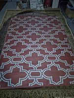 Top view displaying full red and white geometric pattern of plastic rug