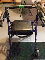 front view of blue rollator walker showing seat, handlebar and wheels