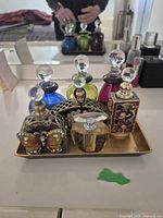 Front view of six perfume bottles on gold tray