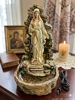Full view of Virgin Mary fountain on table showing power cord
