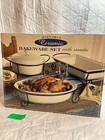 Front of box showing oval dish in cradle, rectangular dish in cradle, round covered dish in stand