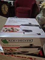 Factory-sealed box showing Black+Decker 6-cup rice cooker and steamer, front angle