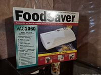 Front of retail box showing FoodSaver VAC1060 vacuum sealer image and features list
