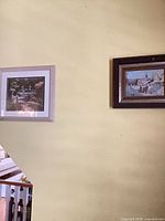 Both framed prints on wall showing relative sizes and frame colours