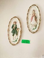 Both oval plaster wall plaques hanging on wall