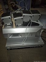 Stacked set showing receiver base, subwoofer and four cube speakers on top