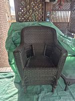 Front view of primary chair showing wicker pattern and armrests