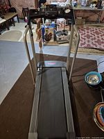 Treadmill unfolded showing belt, console and rails