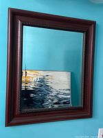 front view of rectangular beveled mirror in wood-tone frame