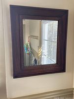 front view of mahogany framed mirror hanging on wall