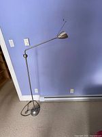 Full view of metal floor lamp against wall