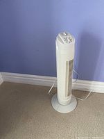 Full view of white tower fan standing on base