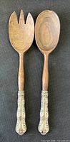 Front view of both wood salad servers showing fork and spoon heads and full length
