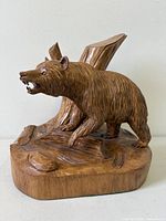 Front view of signed wood grizzly bear sculpture on base