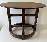 Full view of oak occasional table showing oval top, legs, and stretcher
