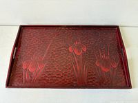 Front view of red lacquered Kamakura-bori tray showing carved floral design and side handles