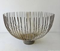 Full side view of silvered wire bowl showing overall form and footed base