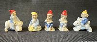 Front view of five Wade gnome figurines lined up