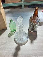 All three items: clear cut glass decanter, Sapporo beer bottle, small green bottle